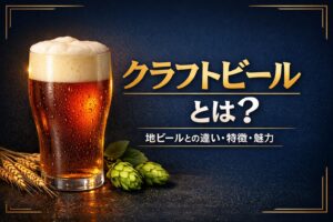 クラフトビールとは何かを解説する記事のアイキャッチ画像。琥珀色のクラフトビールが注がれたグラスとホップをあしらった、紺色と金色基調のデザイン。