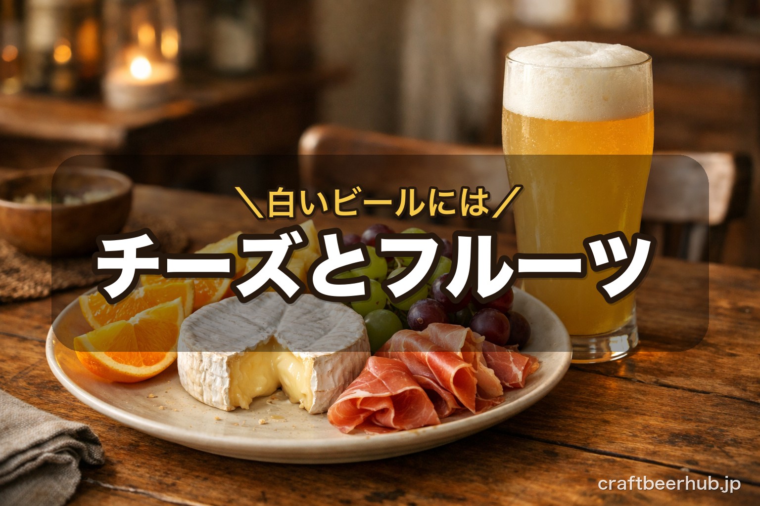 カマンベールチーズとカットフルーツ、生ハムを並べた皿に、白く濁った小麦のビールのグラスが添えられた食卓